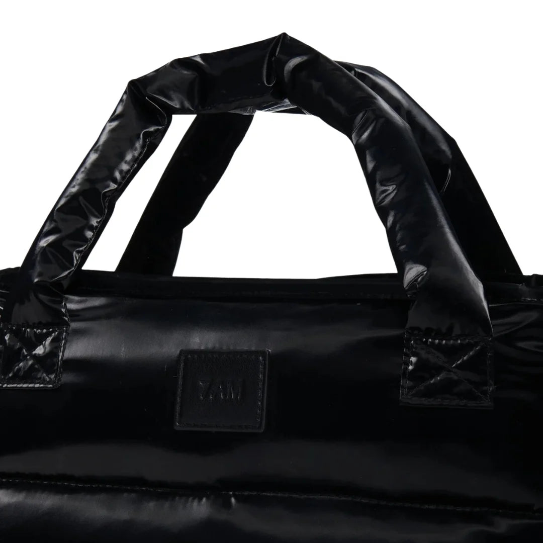 A high-resolution close-up of the polished gloss finish and interior pockets.