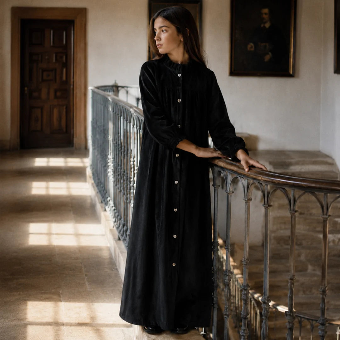 A profile view of the RetroKid girls formal dress in black velvet, showing its graceful length.