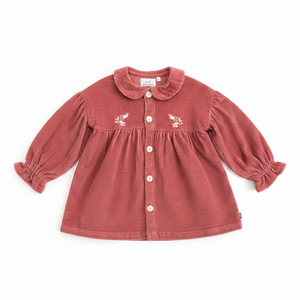 Red children's dress with floral embroidery on a white background