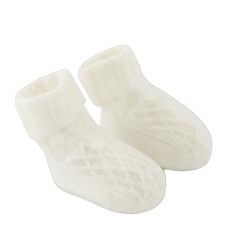 Pair of white baby socks on a light beige background