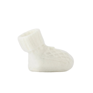 White baby bootie on a beige background