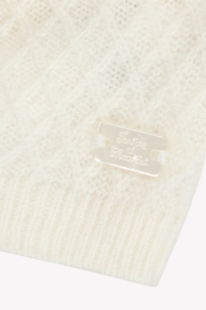 Close-up of a white knit fabric with a brand label on a white background