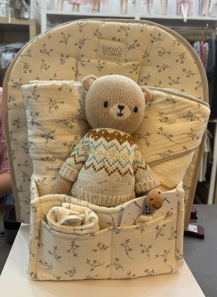 Baby seat with teddy bear and blanket in a store setting