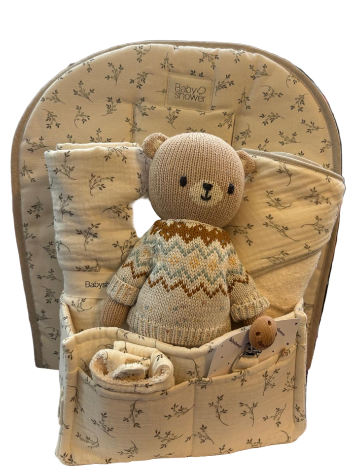 Baby seat with teddy bear and blanket in a store setting