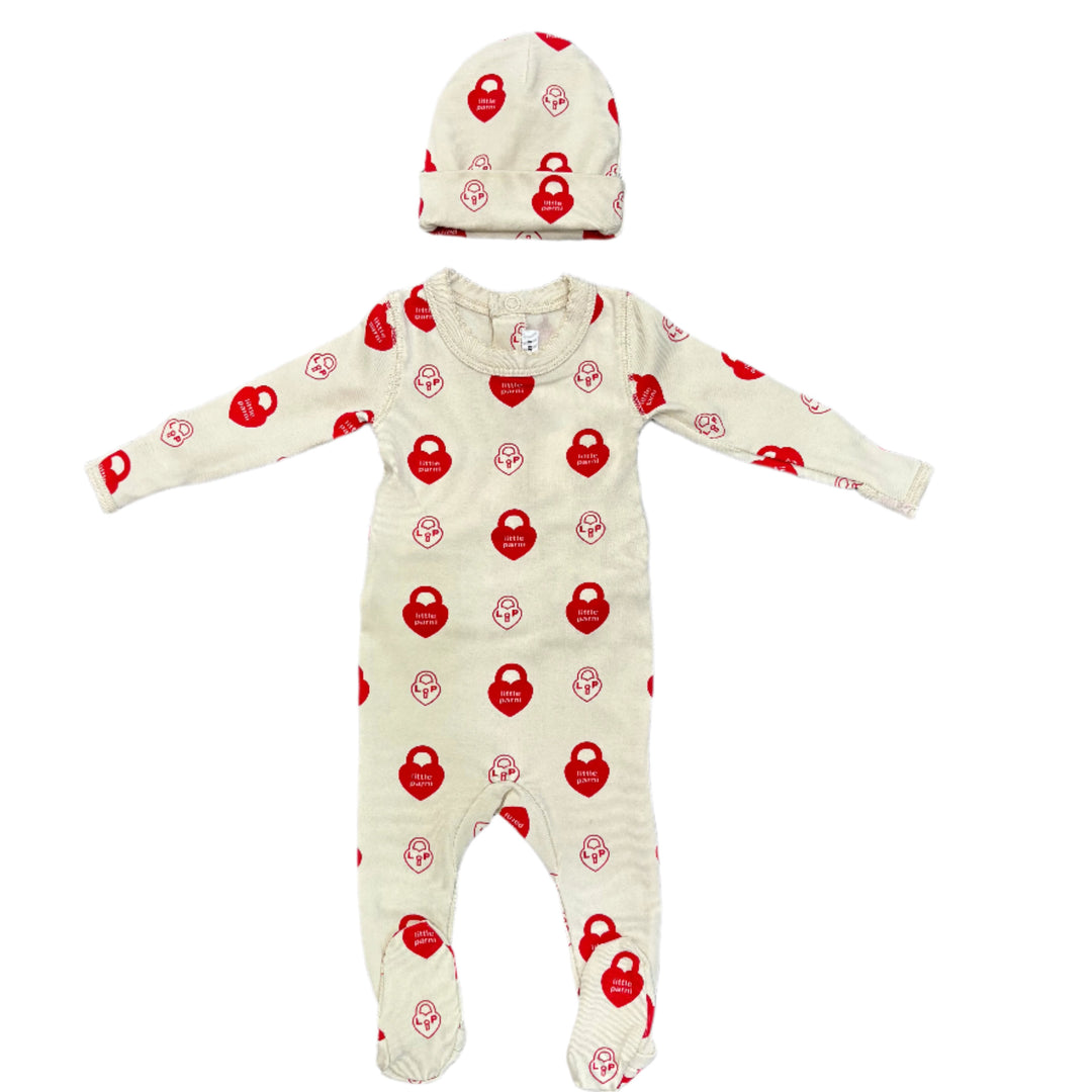 Baby onesie with red patterns on a wooden floor