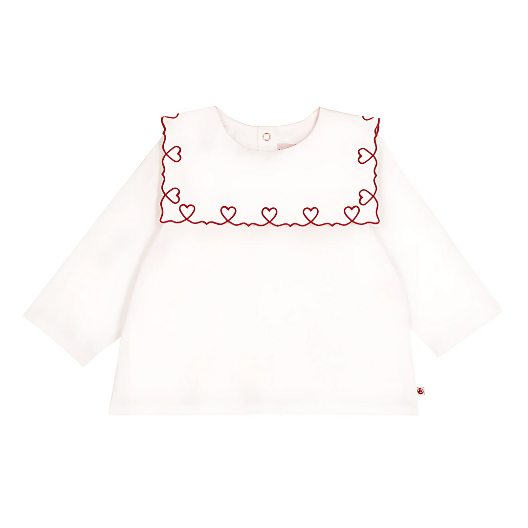 White long-sleeve top with red heart embroidery on a white background