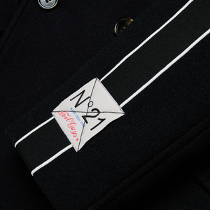 Black coat with a white label featuring 'N 21' on a dark background