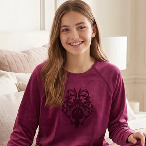 Woman wearing a purple sweater in a cozy bedroom