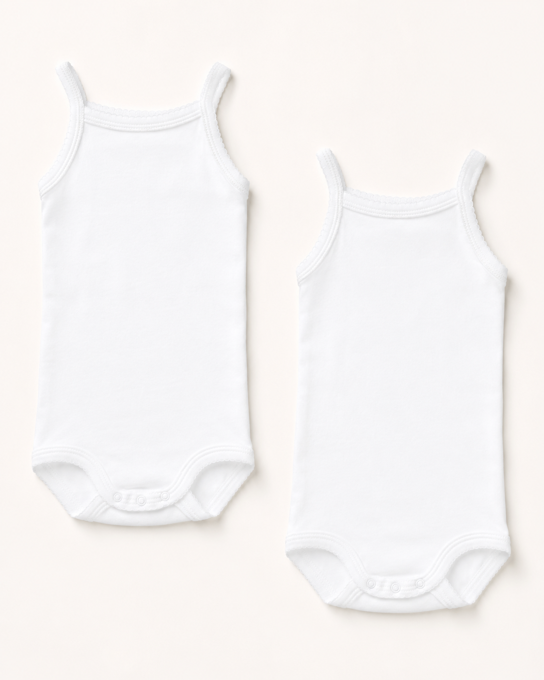 Two white sleeveless baby bodysuits, one smaller and one larger, laid flat on a light cream background.