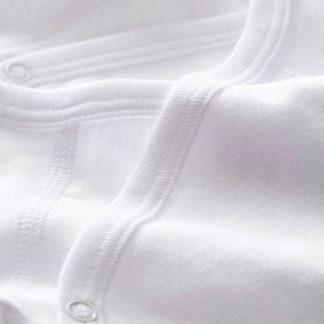 Close-up of white fabric with a button detail