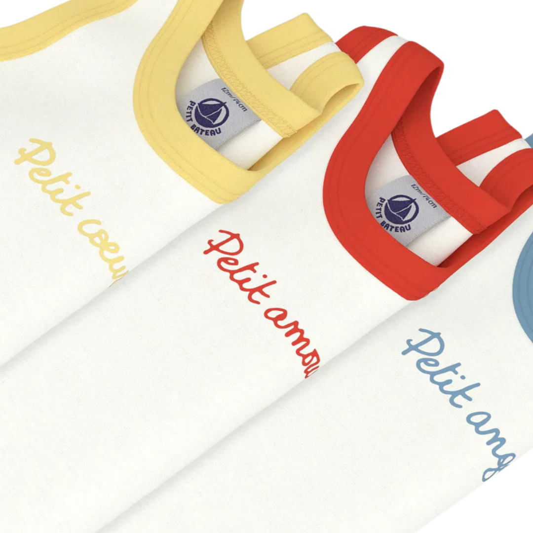 Colorful baby bibs with 'Petit Ami' branding on a white background