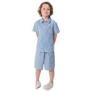 Child wearing a light blue shirt and shorts set on a white background