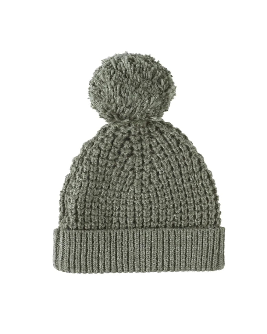 Green knit beanie with pom-pom on a white background