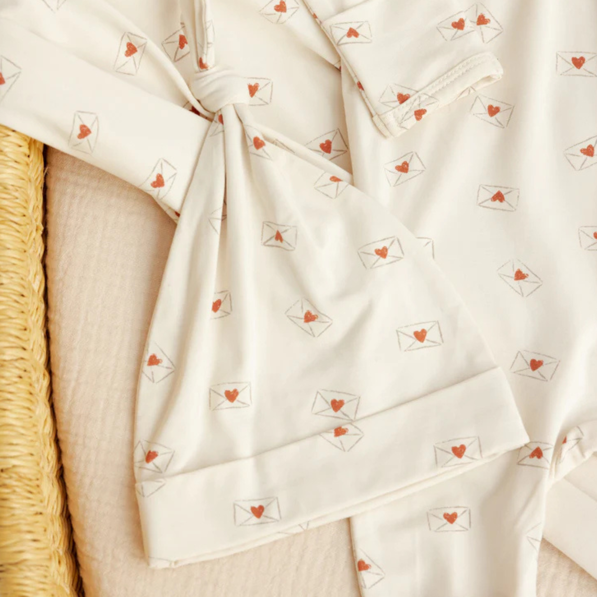 Close-up of a white fabric with red heart patterns on a textured surface.