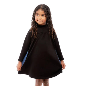Young girl wearing a black dress with a white background
