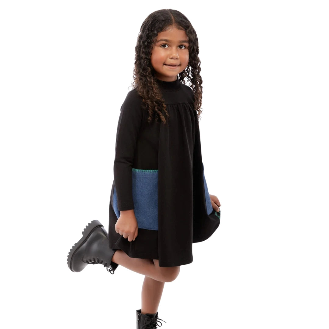 Child wearing a black dress with a blue accent on a white background