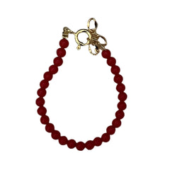 Red beaded bracelet with a gold clasp on a white background