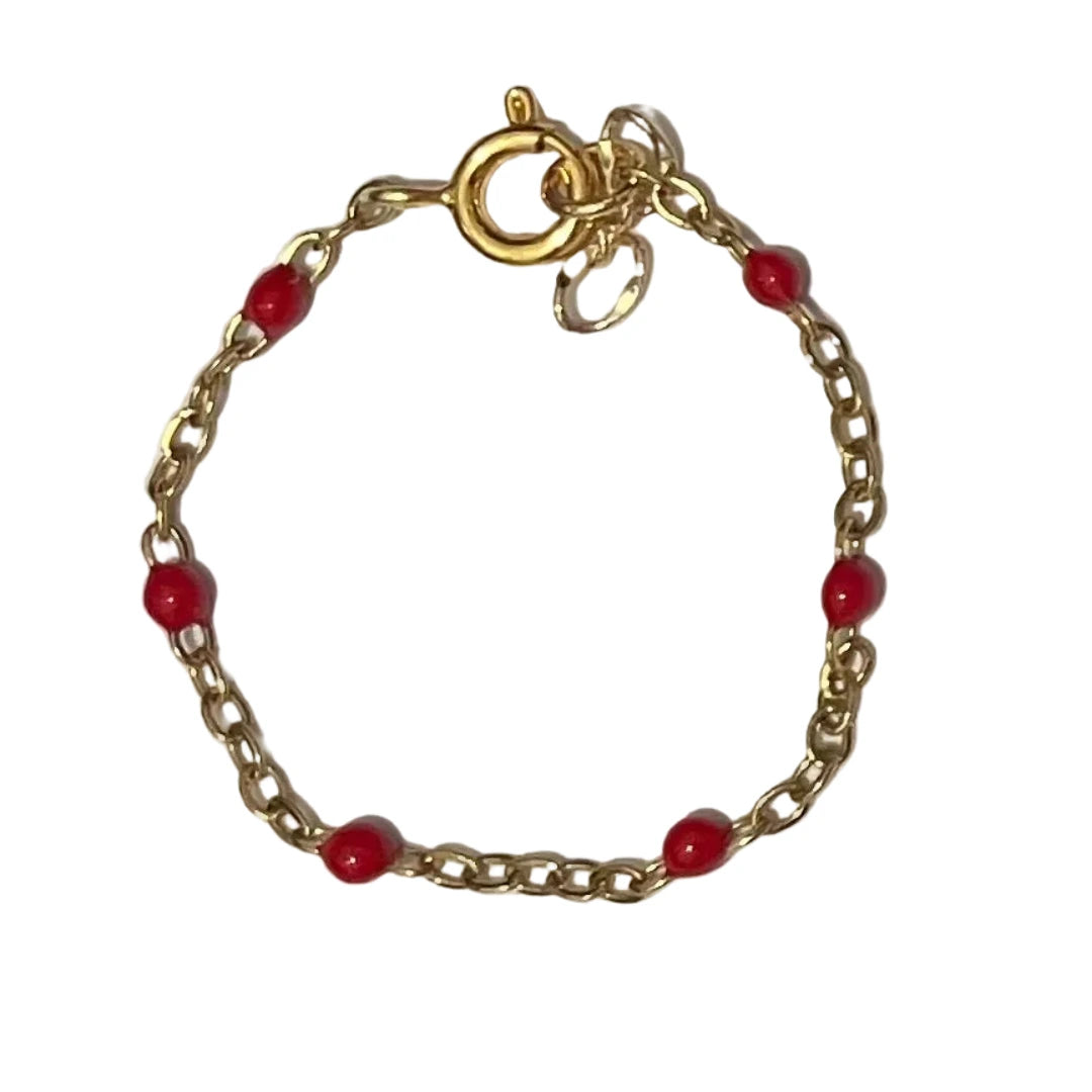 Gold bracelet with red beads on a white background
