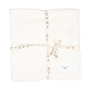 White blanket with gold text on a white background