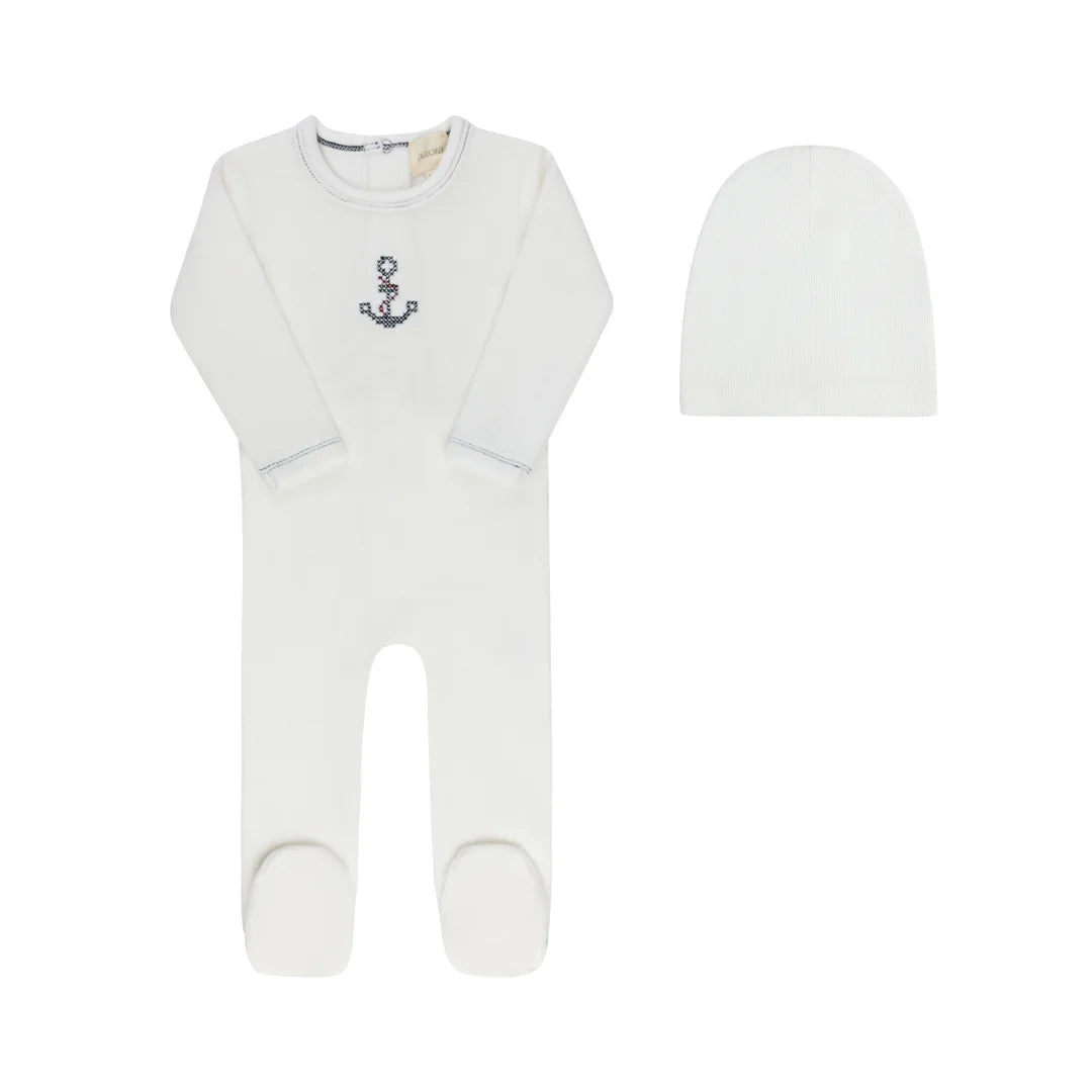 A front view of the Aurora cross-stitch footie and matching beanie set in ivory.