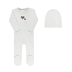 A front view of the Aurora cross-stitch footie and matching beanie set in ivory.