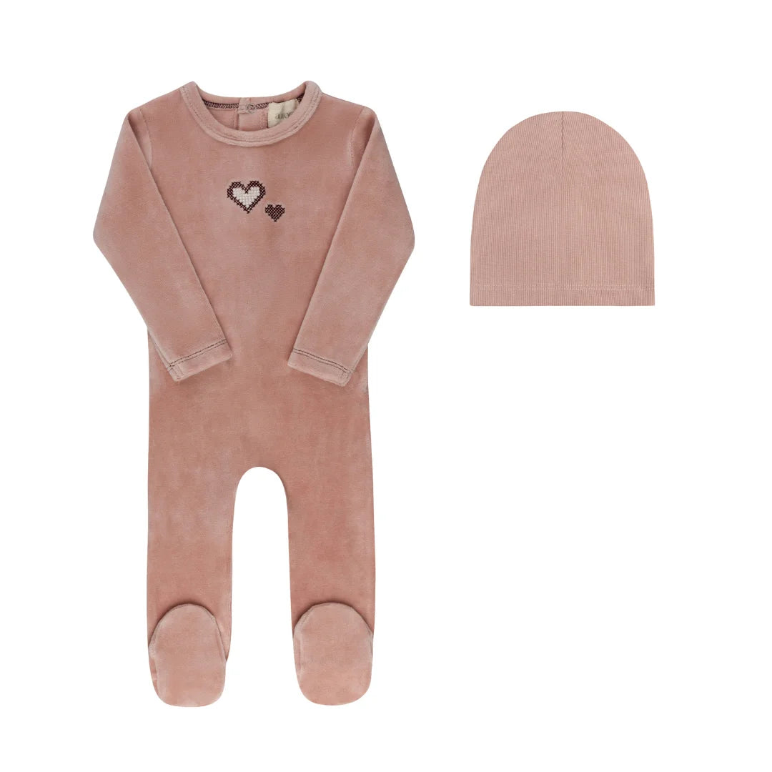A front view of the Aurora cross-stitch footie and matching beanie set in pink.
