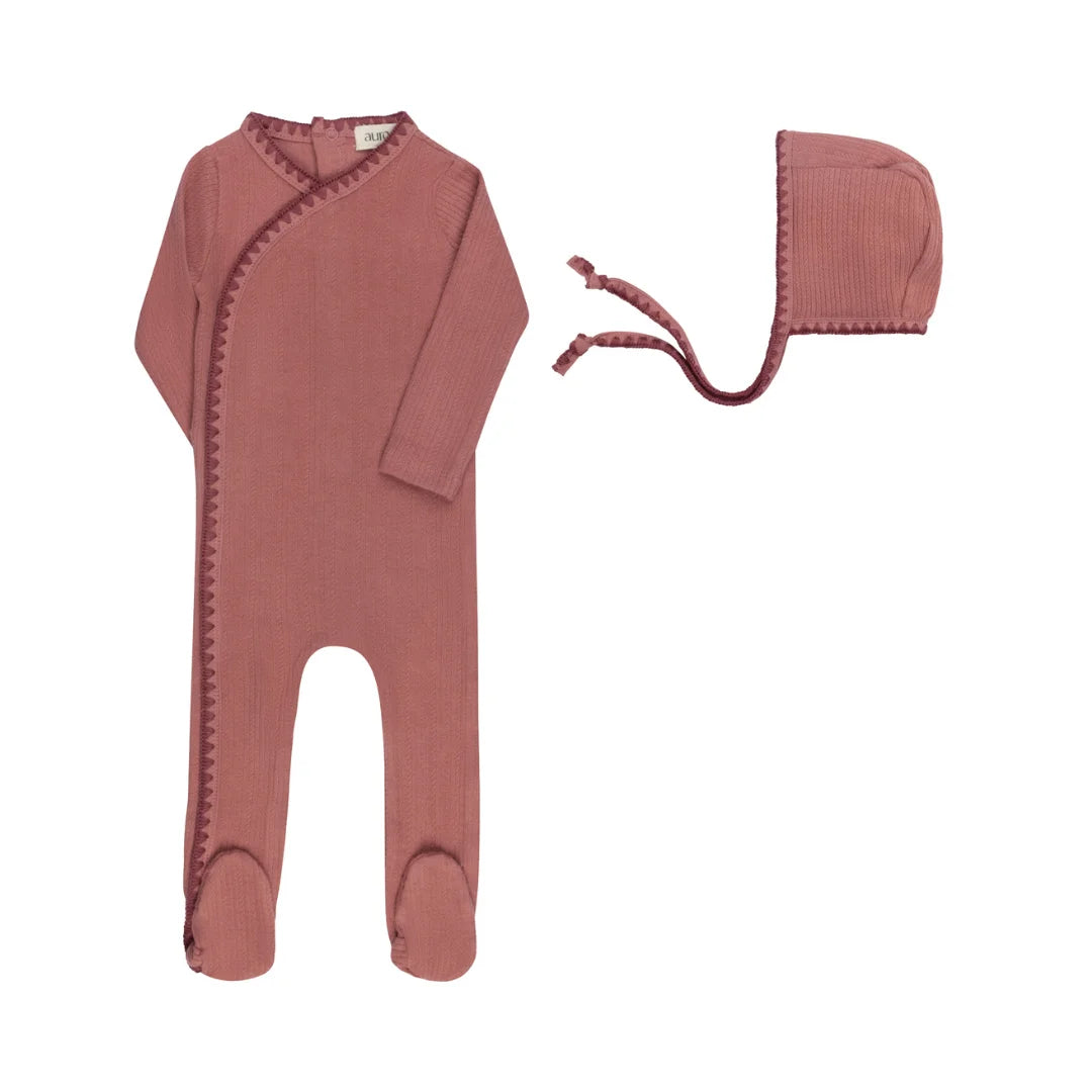 A front view of the Aurora whipstitch footie and matching bonnet set in pink.