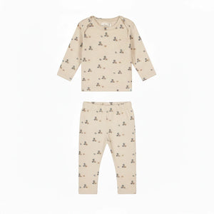A long-sleeve baby t-shirt in cream-colored cotton with a small teddy bear and block print pattern, shown flat on a white background.