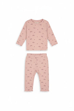 A pink long-sleeve baby top with a small all-over pattern of tiny red bows and white star-shaped embellishments, displayed flat against a solid white background.