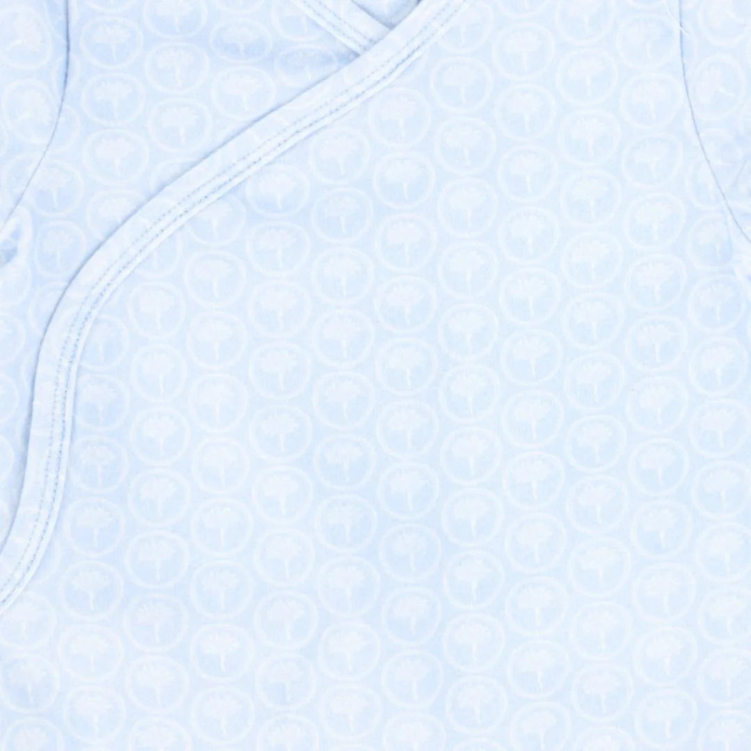 A high-resolution close-up of the delicate floral print and soft organic fabric texture.