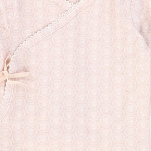 A high-resolution close-up of the delicate floral print and soft organic fabric texture.