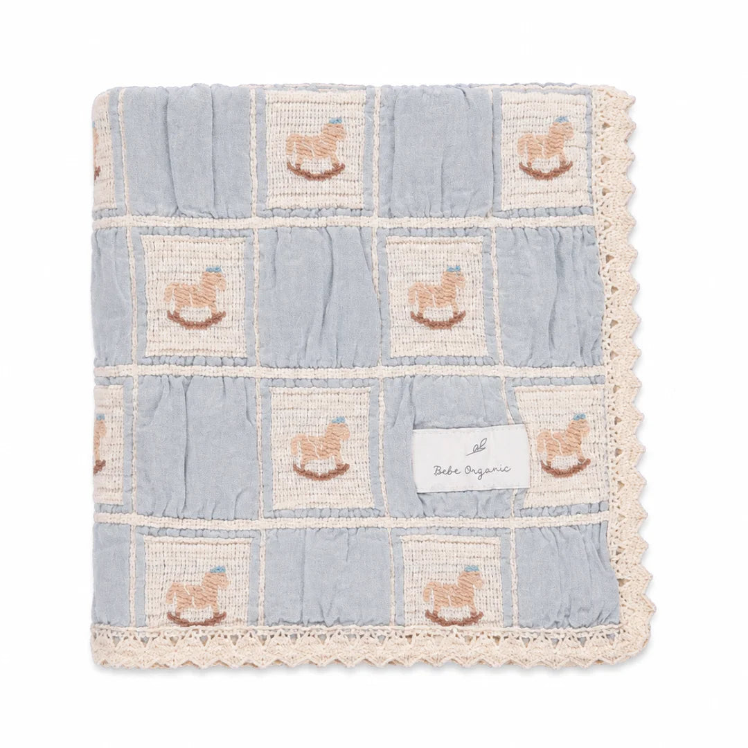 A neatly folded presentation showcasing the patchwork design and lace edges blue