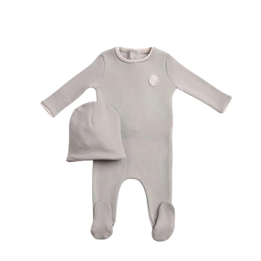 A front view of the elegant chateau stone Bee & Dee cutout footie and beanie set.