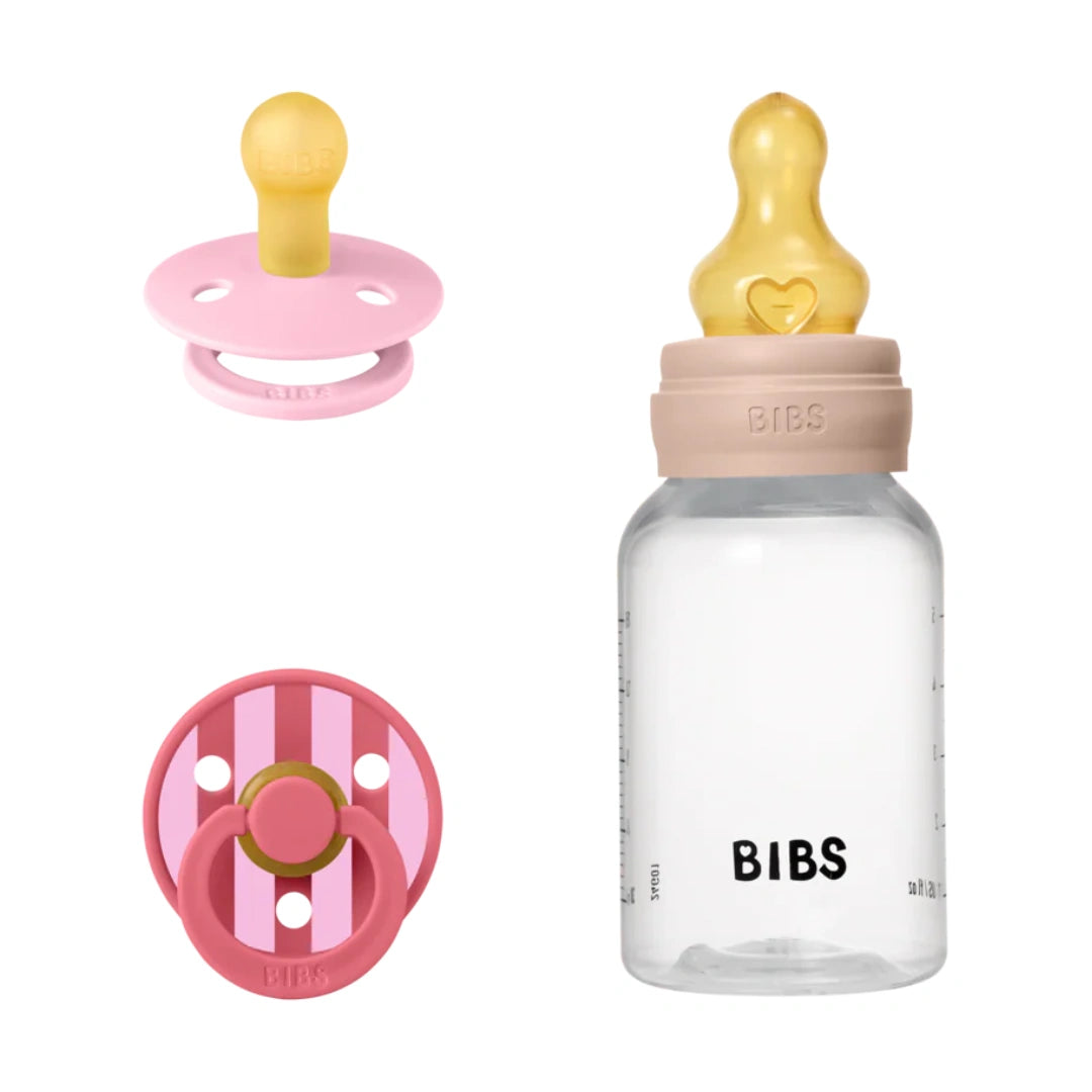 BIBS pacifier and bottle set with pink and gold accents on a white background