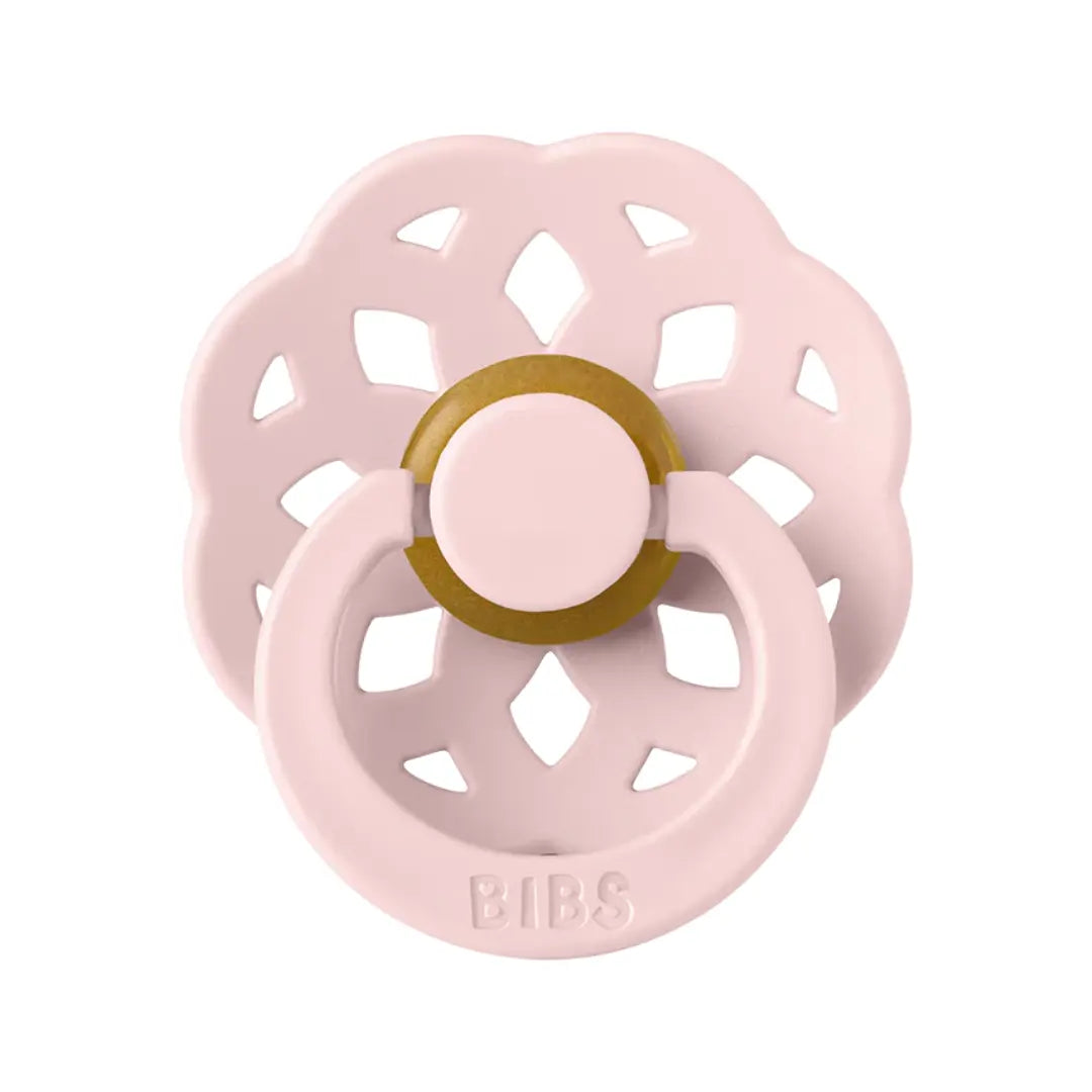 Pink baby pacifier with a gold ring on a white background