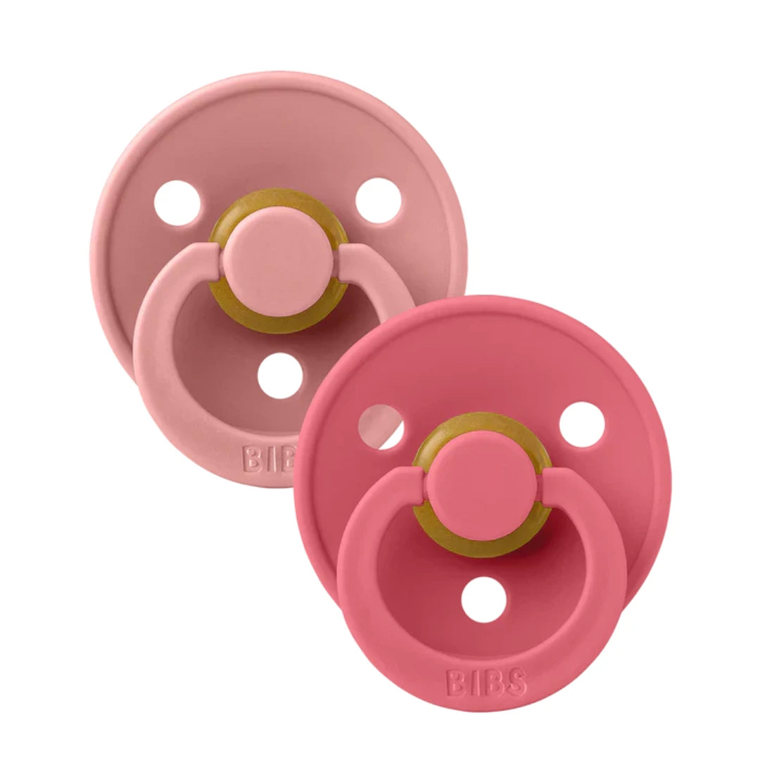 A breathtaking BIBS Colour Pacifier 2-Pack in Dusty Pink and Coral, showcasing its immaculate minimalist shield and premium round natural rubber nipple.