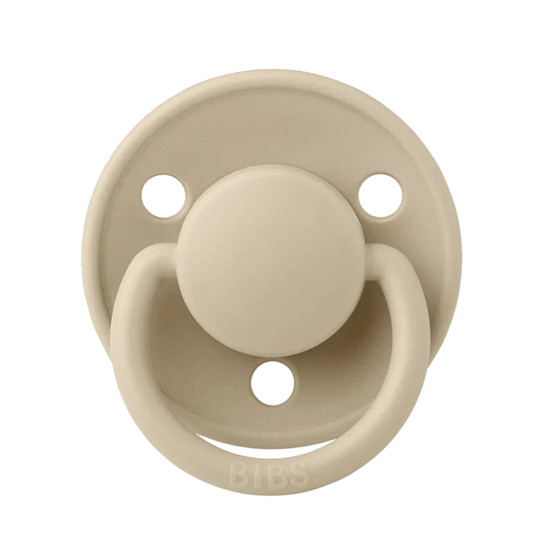 A breathtaking BIBS De Lux Silicone Pacifier in Vanilla, showcasing its immaculate minimalist shield and premium clear silicone nipple.