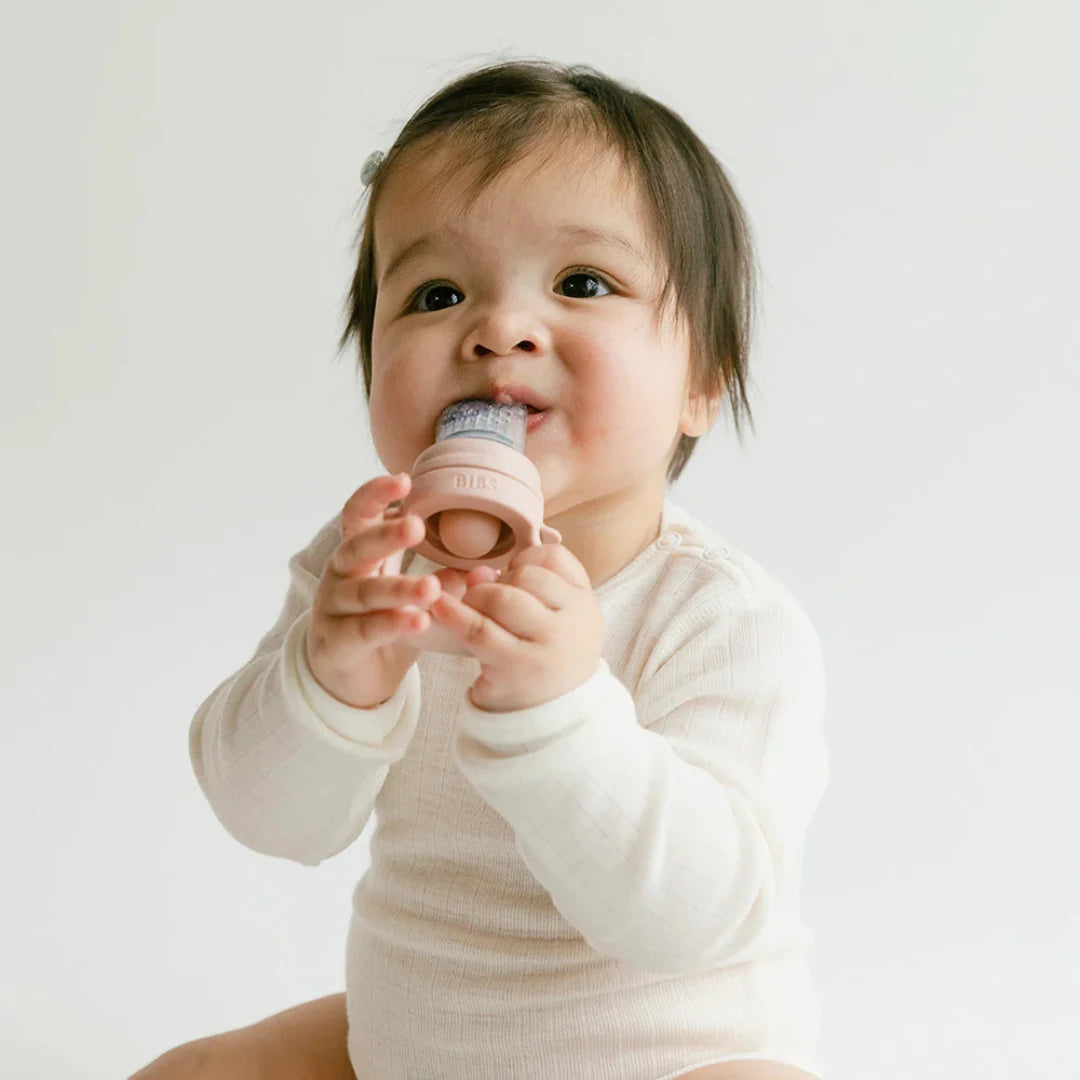 Baby holding a pink toy with a white background