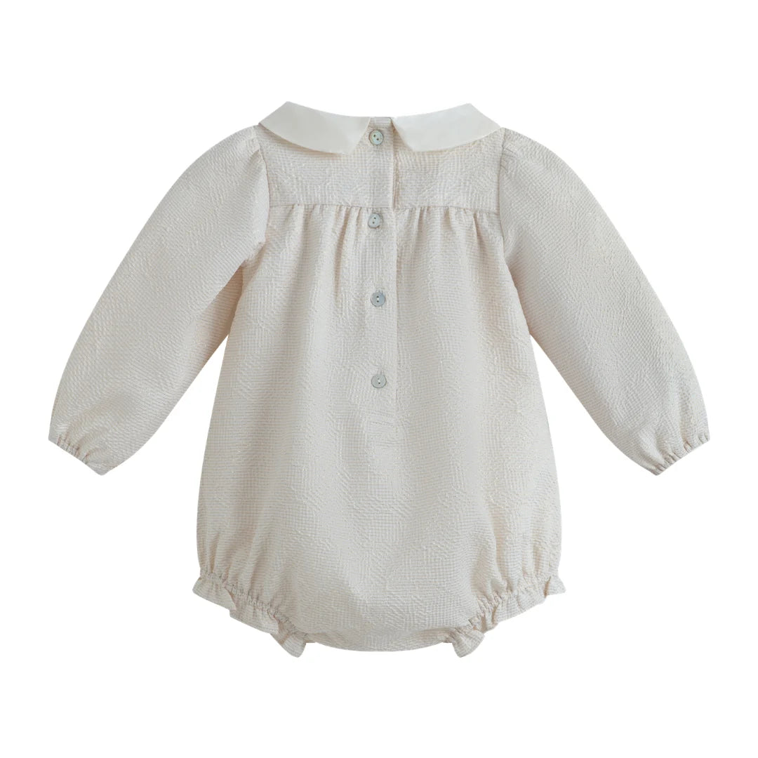 Beige baby romper with long sleeves on a white background