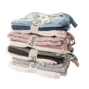 Stack of folded baby blankets with visible brand label on a white background