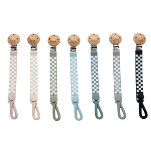 Set of pacifier clips with checkered patterns and wooden beads on a white background