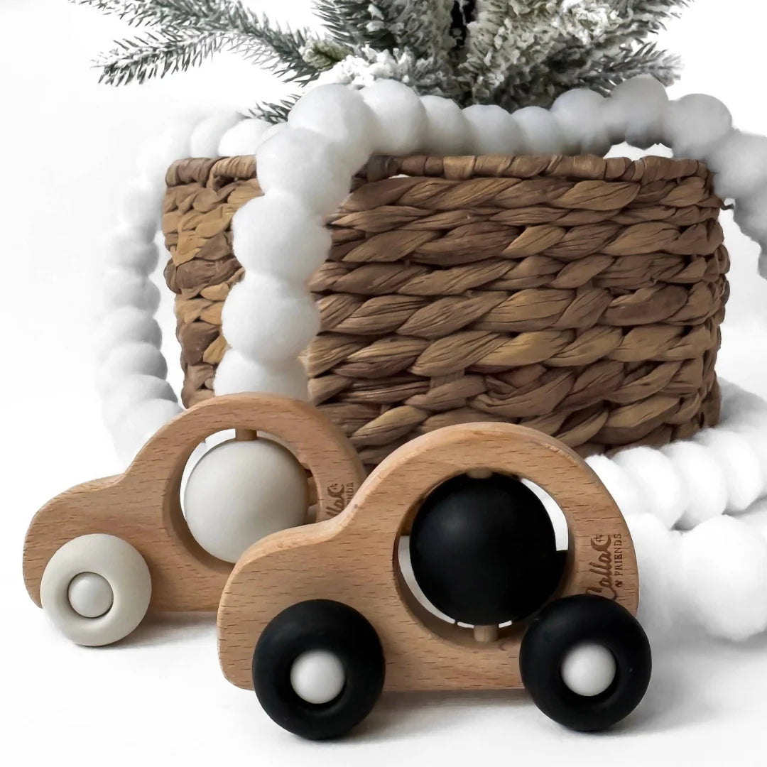 Wooden toy cars with black and white tires on a snowy background