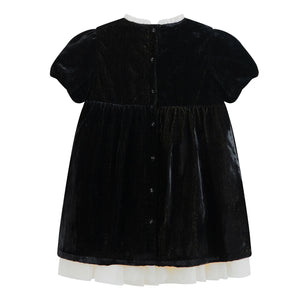 Black velvet dress with white trim on a white background