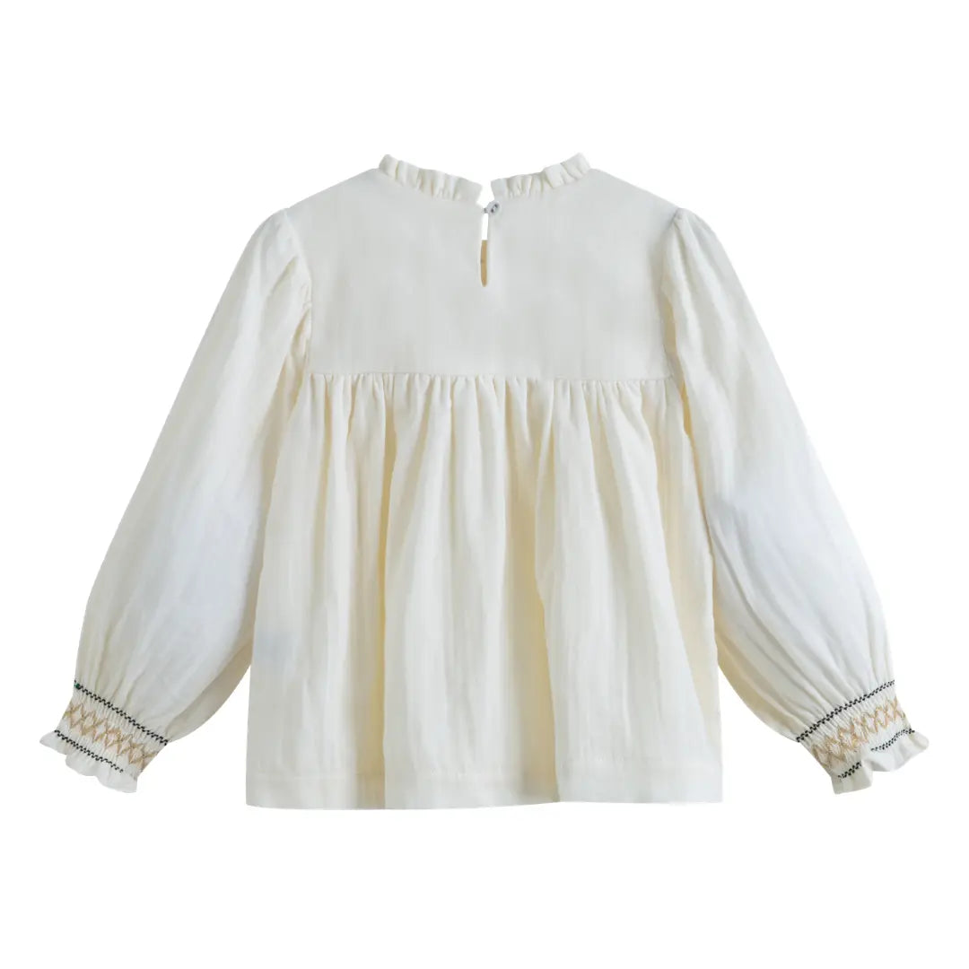 White blouse with long sleeves and decorative cuffs on a white background