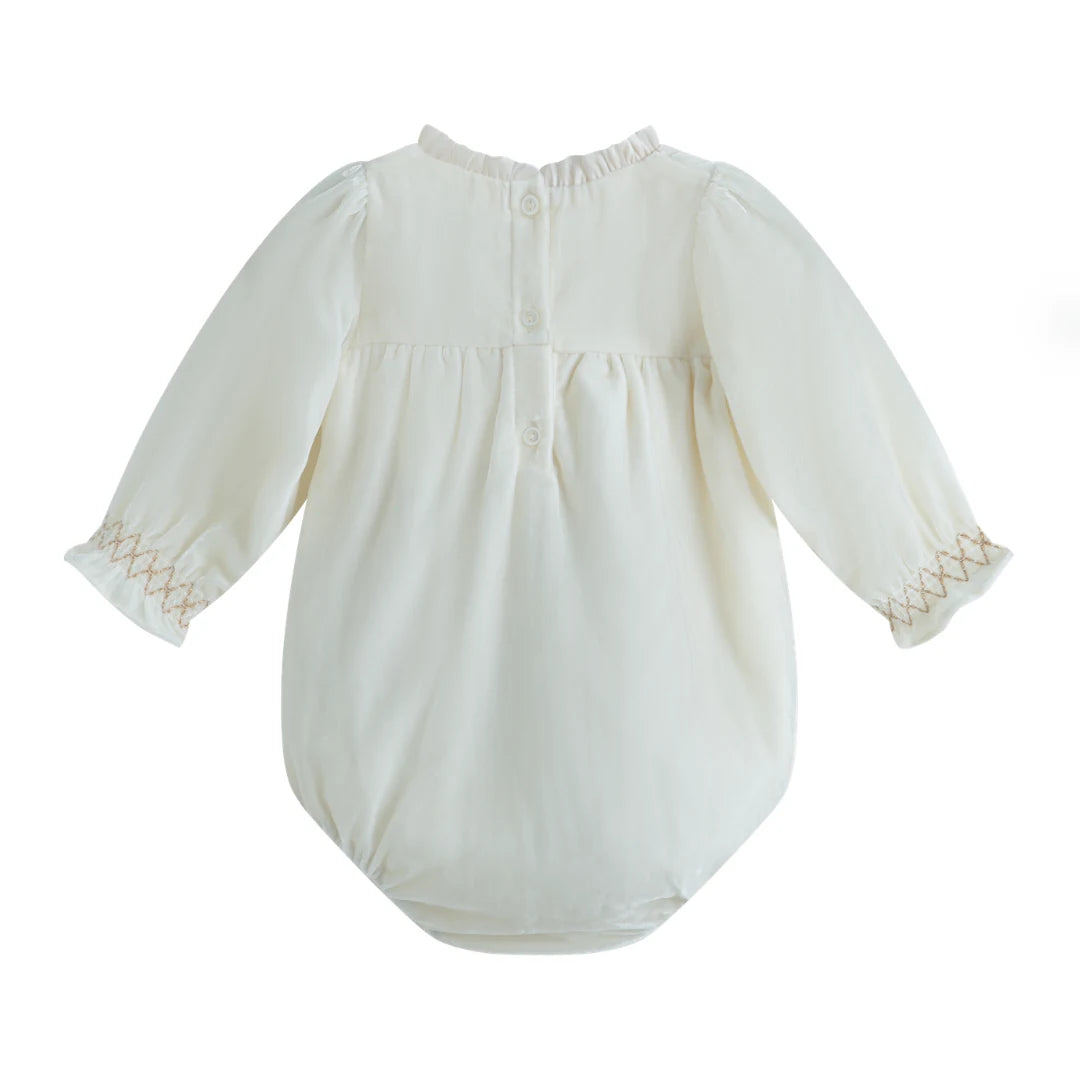 White baby romper with lace details on a white background