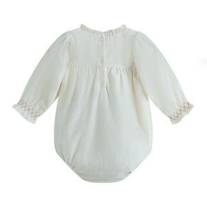 White baby romper with lace details on a white background