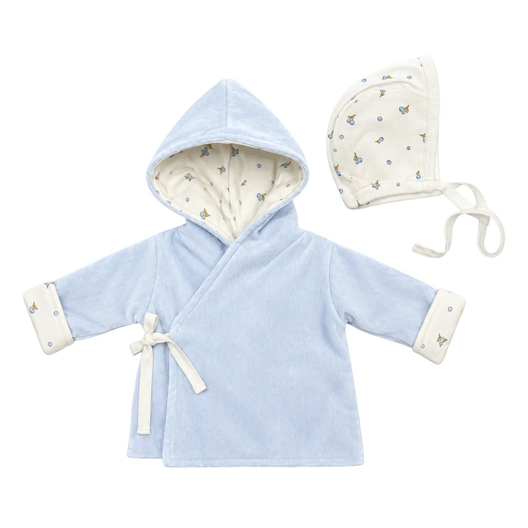 A flat-lay view of the Coton Pompom blueberry bambino jacket and bonnet set in light blue.