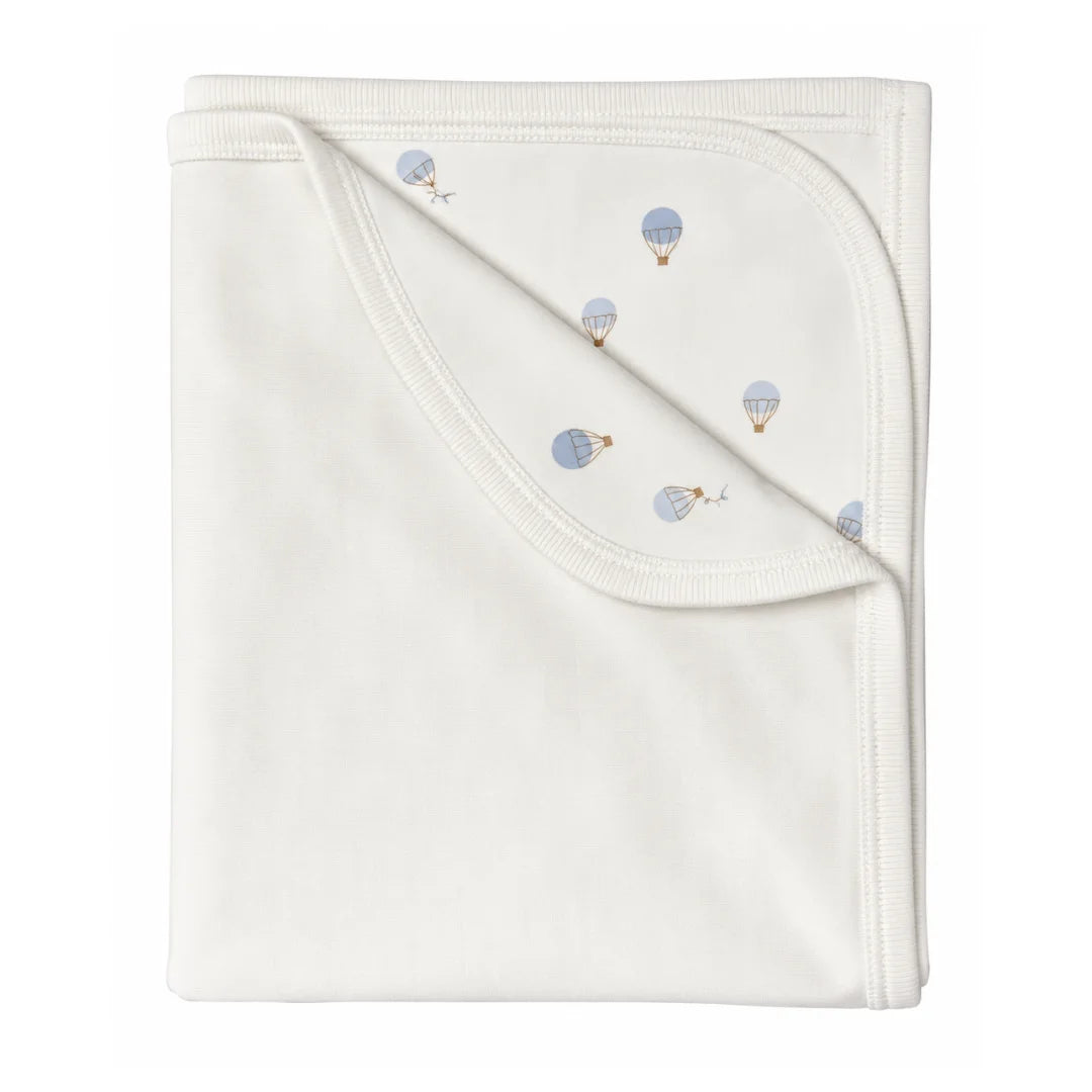A flat-lay view of the Coton Pompom Dreamy Air Balloons corduroy blanket in ivory.