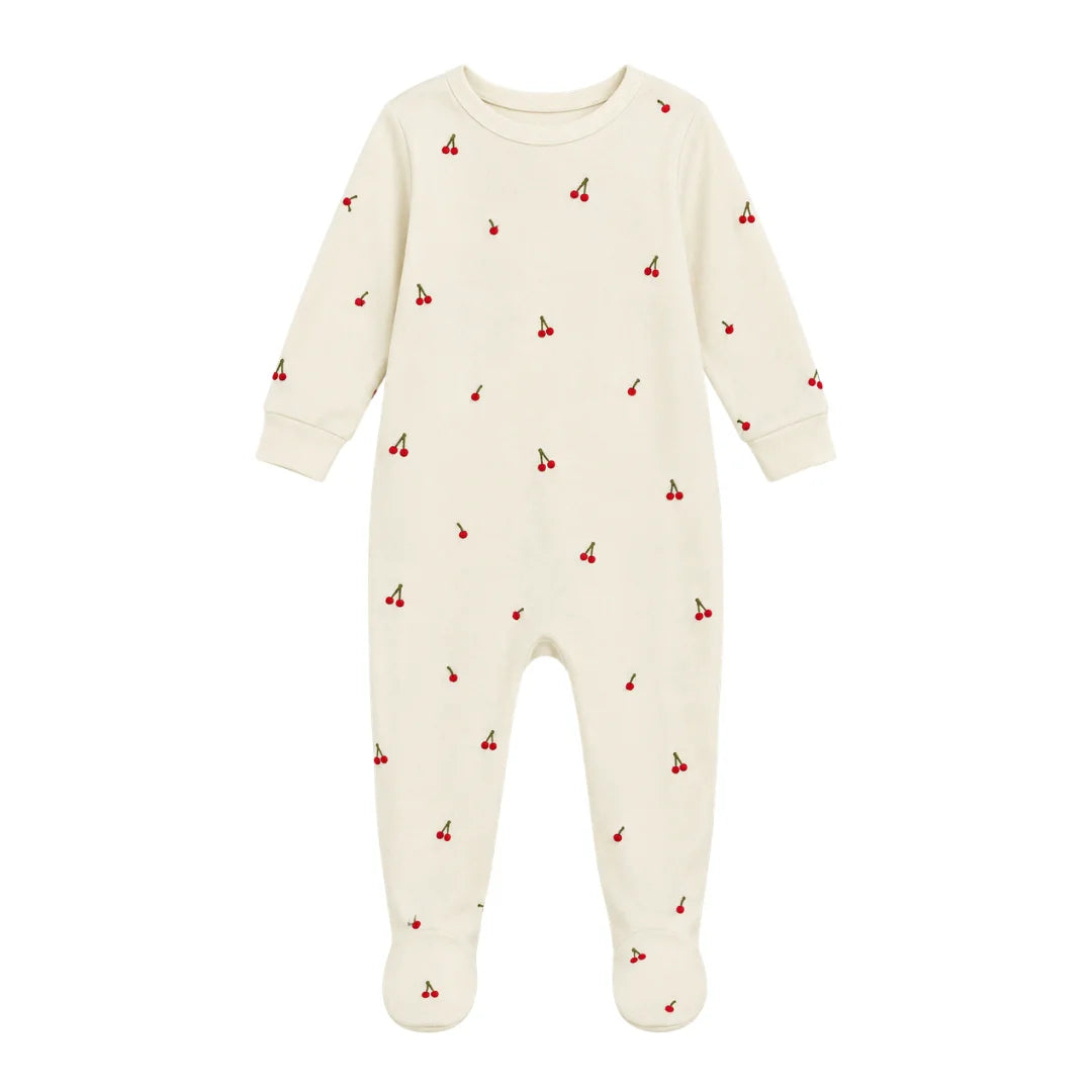 A flat-lay view of the Coton Pompom mini cherries footie in ivory.