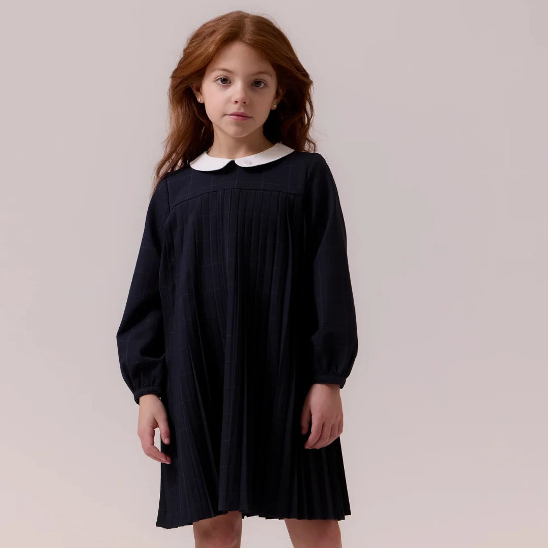 child wearing the Cottier navy dress happily during a family celebration.